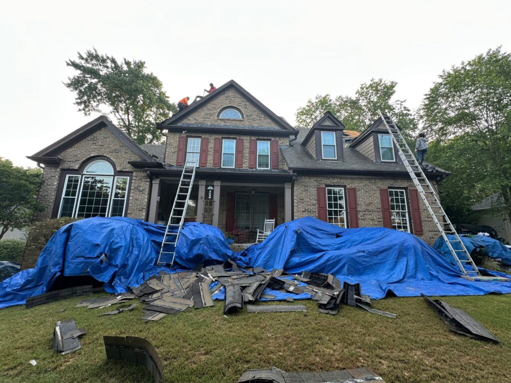 Front view of a large brick home undergoing professional exterior restoration.